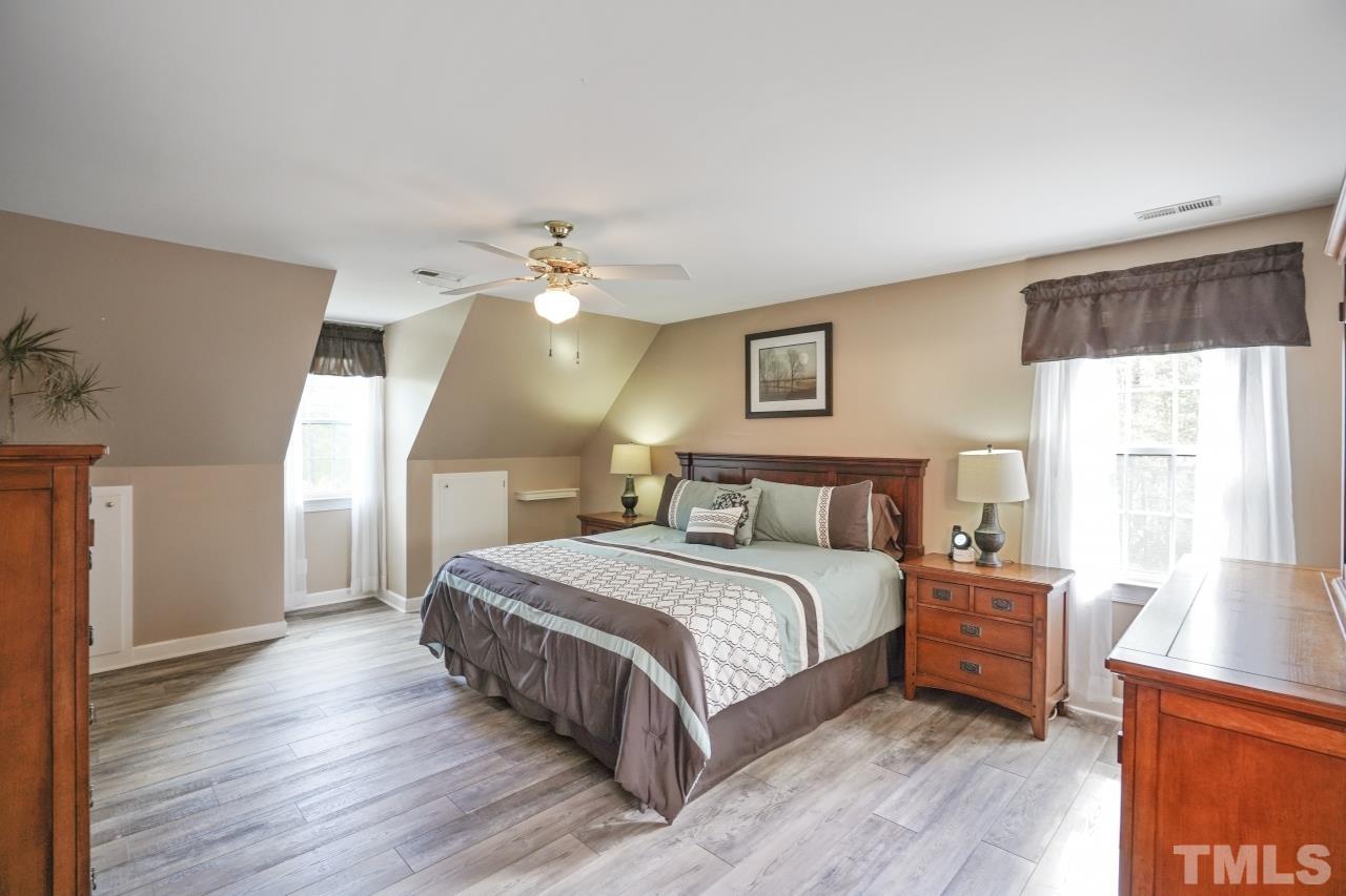 1505 Habbot Drive Raleigh, NC 27603 - Photo 17 of 32 a spacious bedroom with a bed and a chandelier