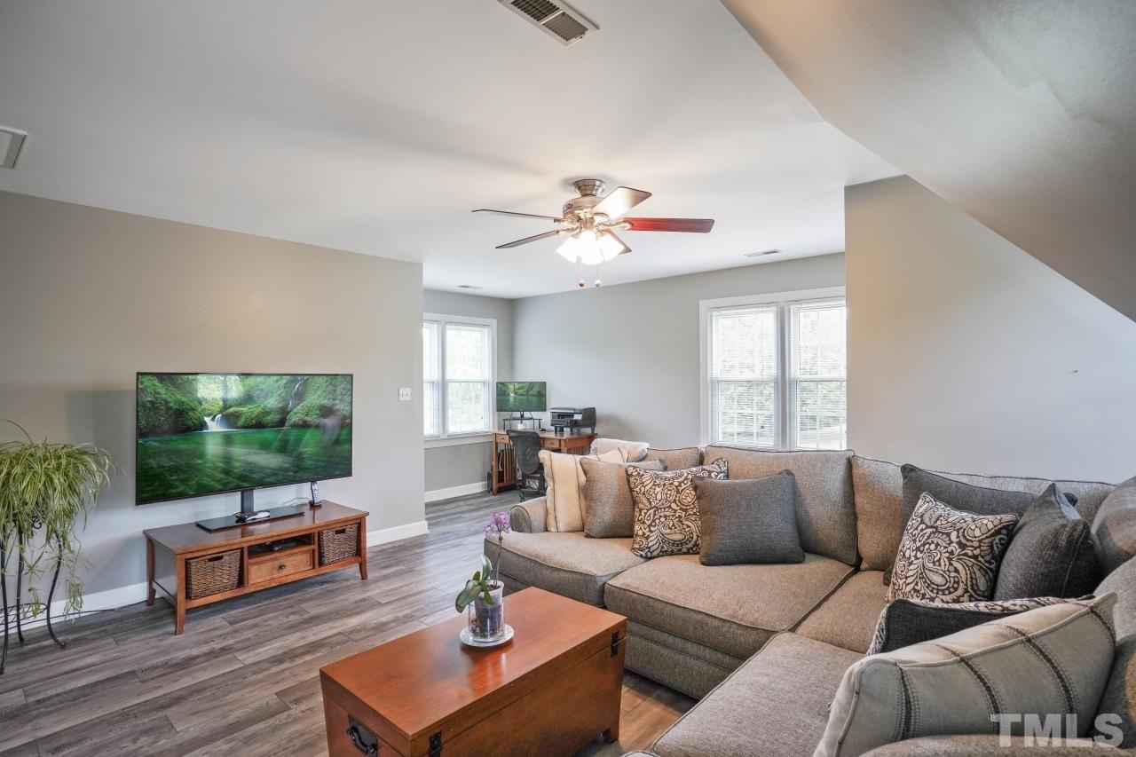 1505 Habbot Drive Raleigh, NC 27603 - Photo 25 of 32 a living room with furniture a flat screen tv and a large window