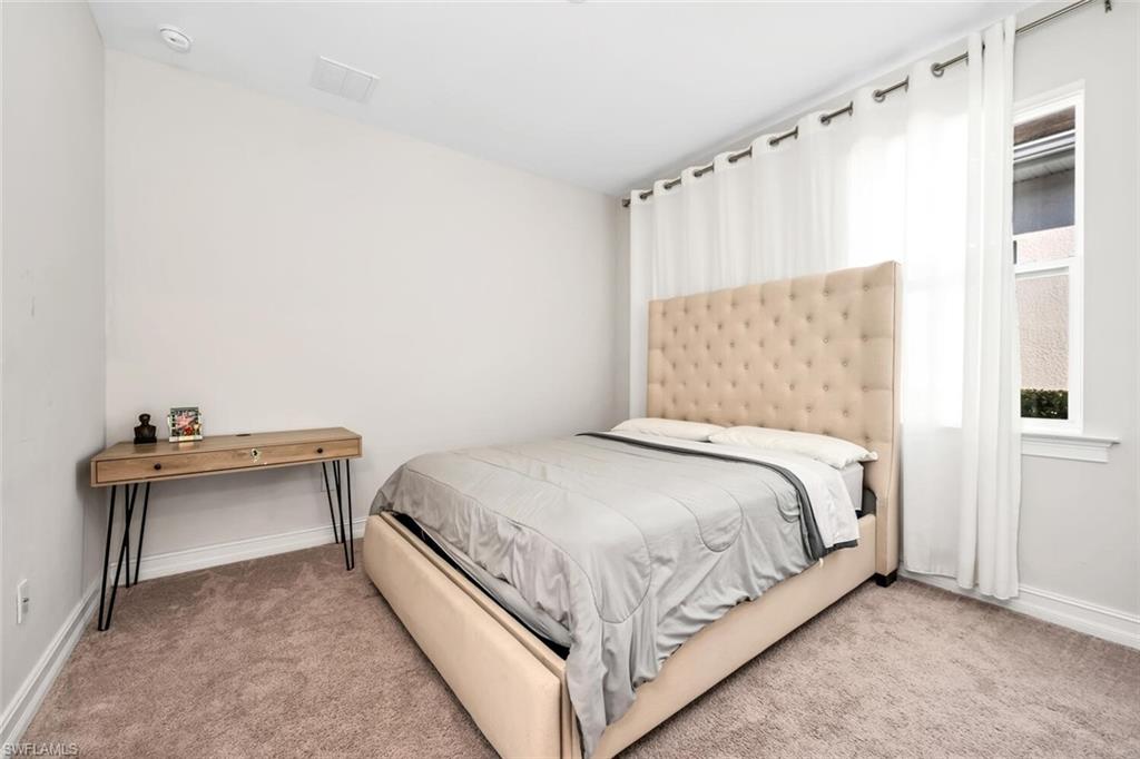 28041 Captiva Shell Loop Bonita Springs, FL 34135 - Photo 9 of 24 a bedroom with a bed and a table