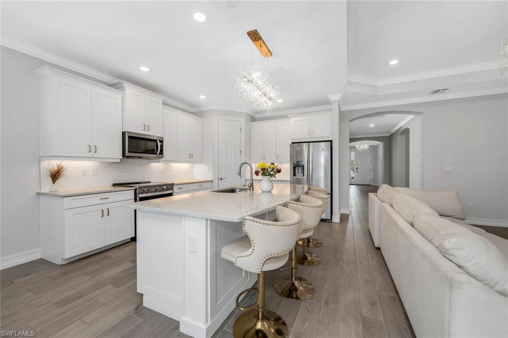 28041 Captiva Shell Loop Bonita Springs, FL 34135 - Photo 2 of 24 a large white kitchen with white cabinets and stainless steel appliances
