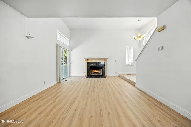 a view of empty room with wooden floor and fireplace