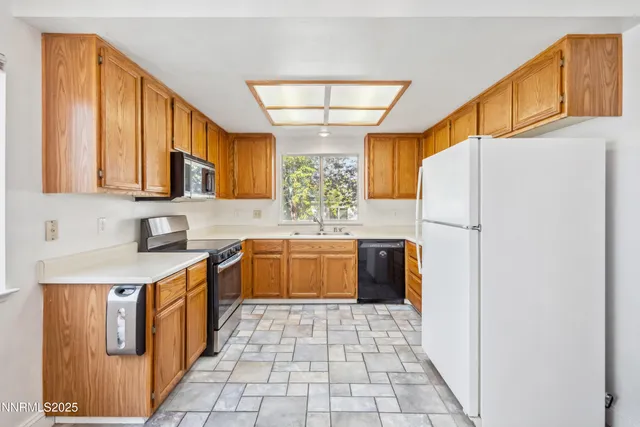 a kitchen with stainless steel appliances granite countertop a refrigerator and a stove