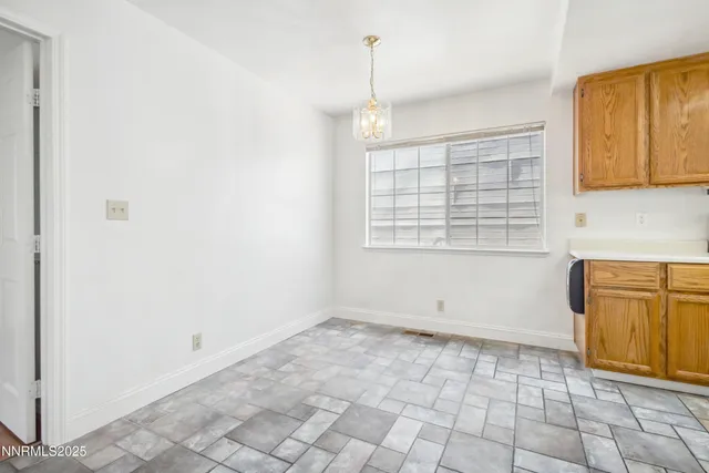 an empty room with windows and cabinet