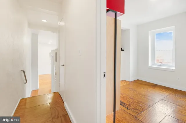 a view of a room with wooden floor and white walls
