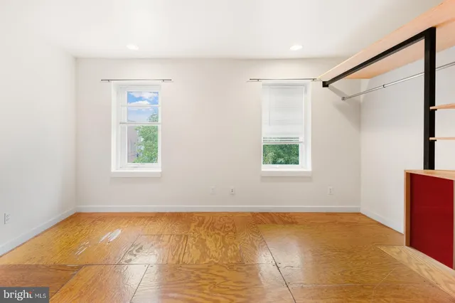 a view of empty room with window and wooden floor