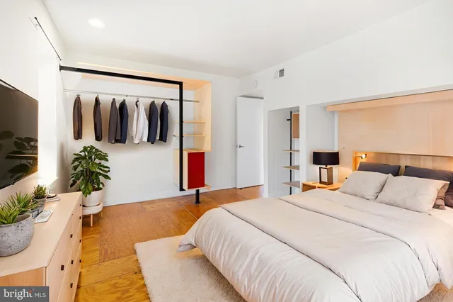 a bedroom with a large bed and potted plant
