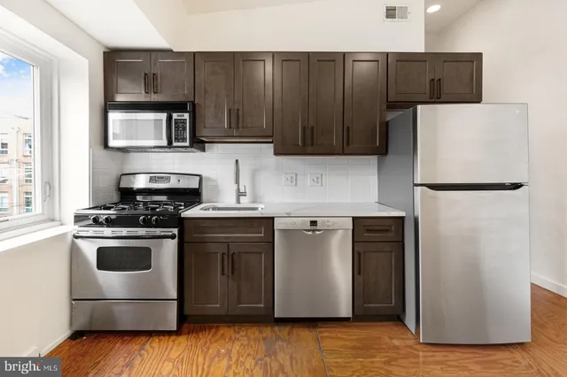 a kitchen with a stove a refrigerator and a sink