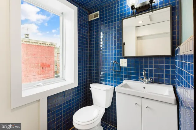 a bathroom with a toilet a sink and a window