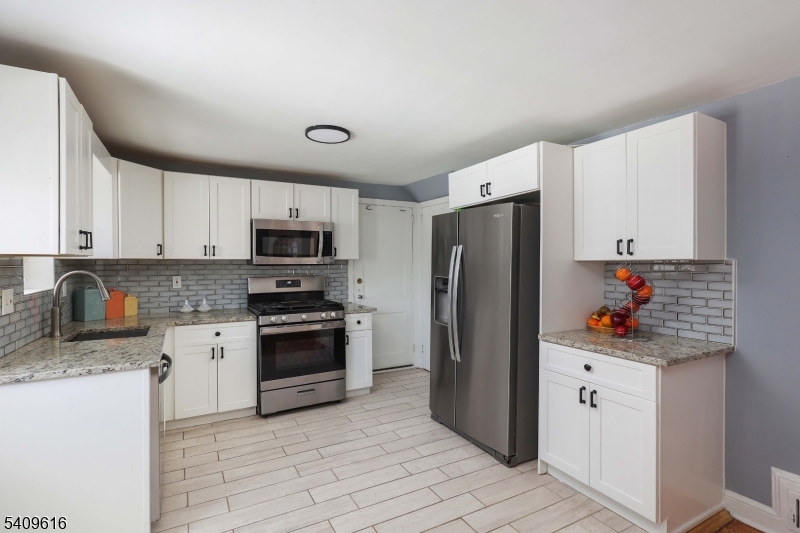 1841 Cider Mill Road Union, NJ 07083 - Photo 10 of 36 a kitchen with stainless steel appliances a refrigerator sink and cabinets