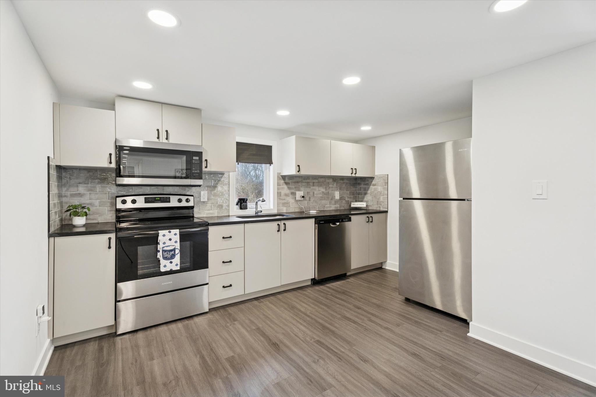 a kitchen with stainless steel appliances granite countertop a refrigerator stove a sink and a microwave