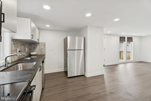 a kitchen with stainless steel appliances granite countertop a refrigerator a sink and a stove