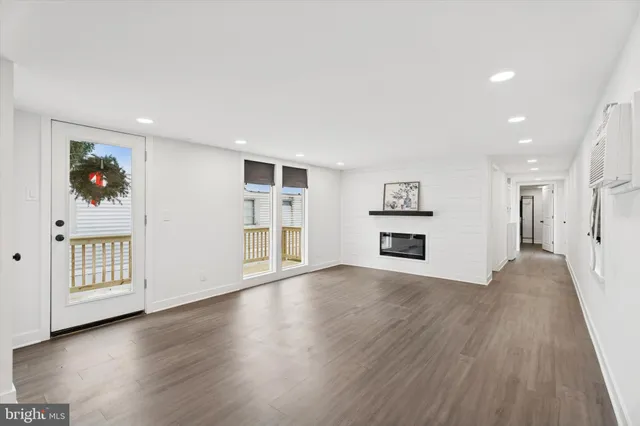 a view of a big room with wooden floor and windows