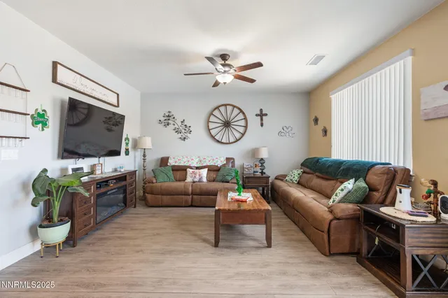 a living room with furniture a flat screen tv and a window