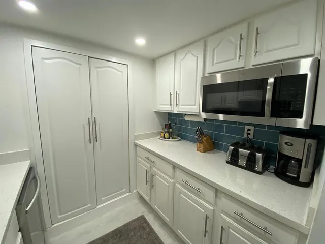 a kitchen with a sink a refrigerator and cabinets
