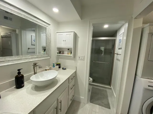a bathroom with a sink and mirror with bathtub