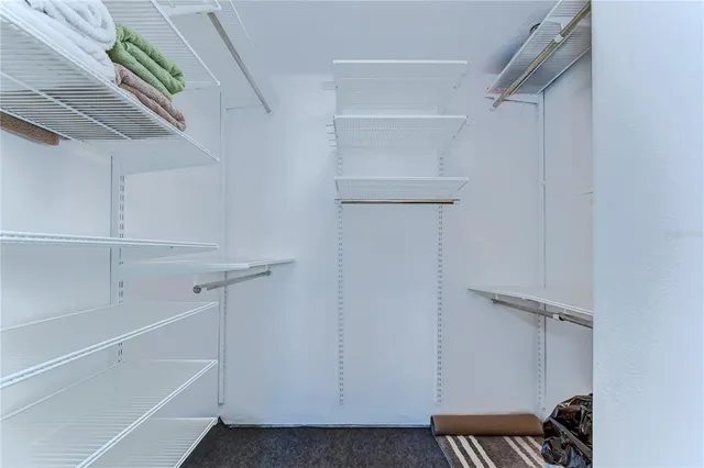 a view of walk in closet with empty racks