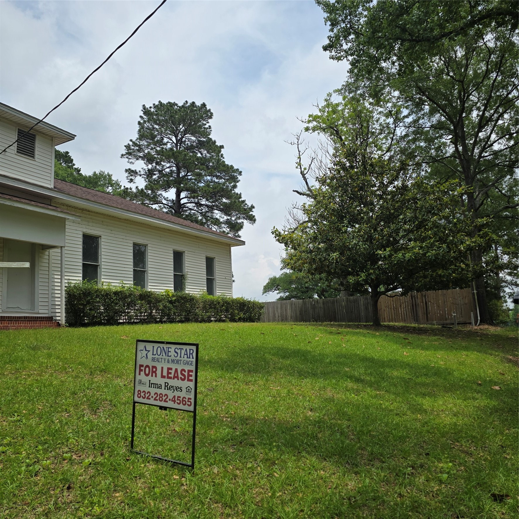 142 Rowe Lane Moscow, TX 75960 - Photo 2 of 16 a view of a white house in front of a big yard with large trees