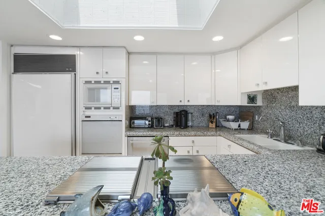 a kitchen with stainless steel appliances granite countertop a refrigerator sink and white cabinets