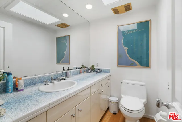 a bathroom with a granite countertop toilet a sink and mirror