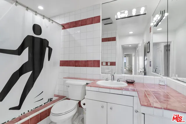 a bathroom with a sink a toilet a mirror and shower