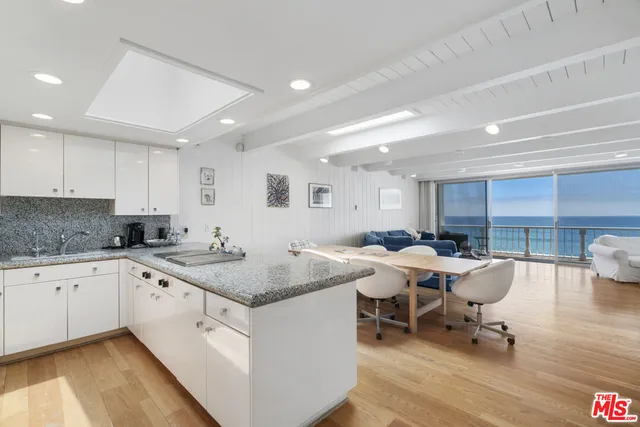 a kitchen with a sink and chairs