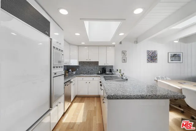 a kitchen with granite countertop cabinets stainless steel appliances a sink and a counter top space