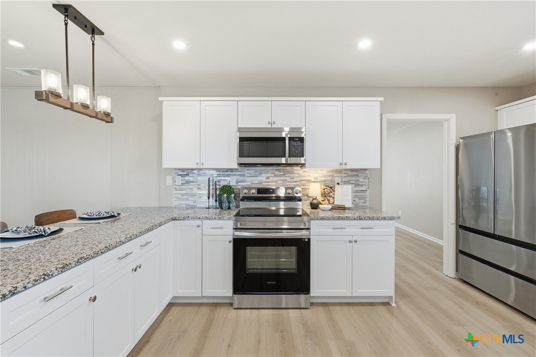 6950 Stallion Road Temple, TX 76501 - Photo 14 of 41 a kitchen with stainless steel appliances granite countertop a stove a sink and a refrigerator