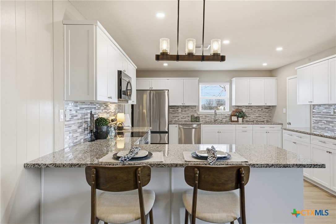 6950 Stallion Road Temple, TX 76501 - Photo 16 of 41 a kitchen with stainless steel appliances granite countertop a sink and cabinets