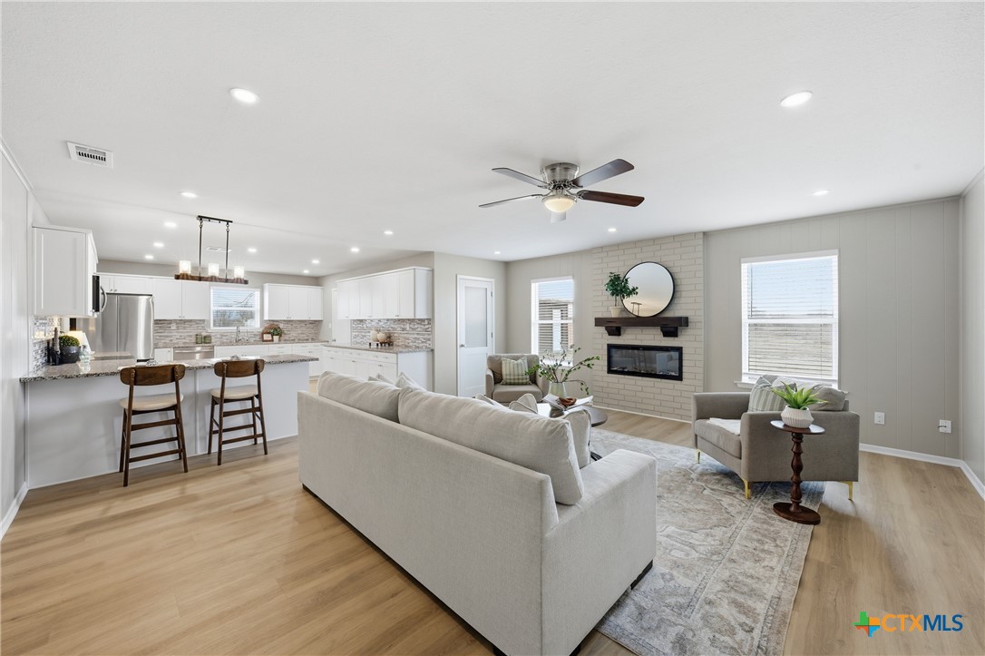 6950 Stallion Road Temple, TX 76501 - Photo 7 of 41 a living room with furniture kitchen view and a wooden floor