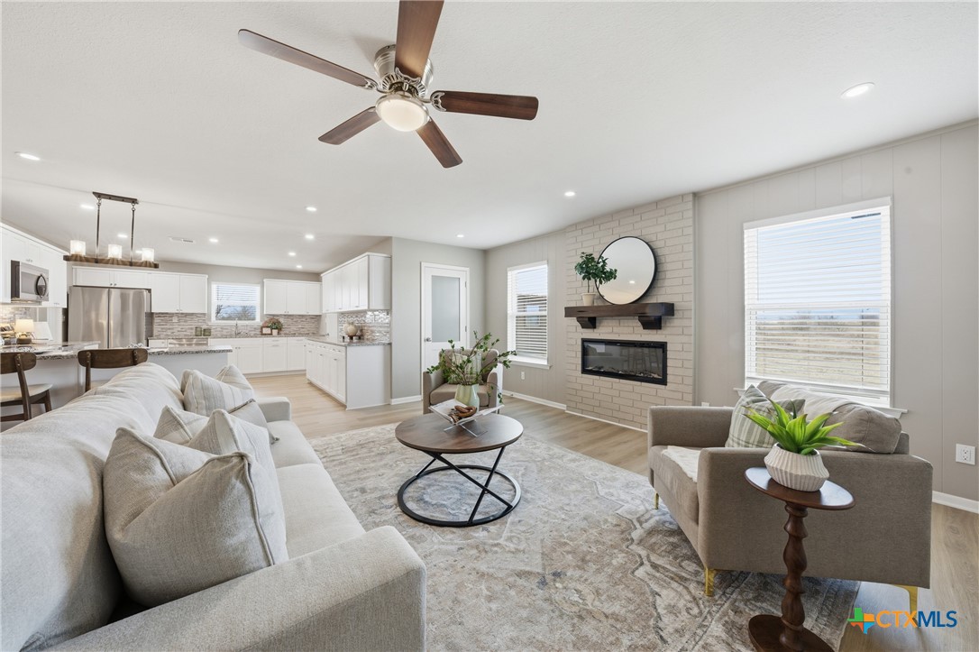 6950 Stallion Road Temple, TX 76501 - Photo 8 of 41 a living room with furniture kitchen view and a wooden floor