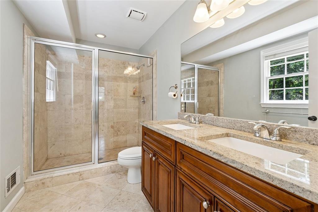 3675 Toxaway Court Chamblee, GA 30341 - Photo 20 of 37 a bathroom with a granite countertop sink a toilet a mirror and shower