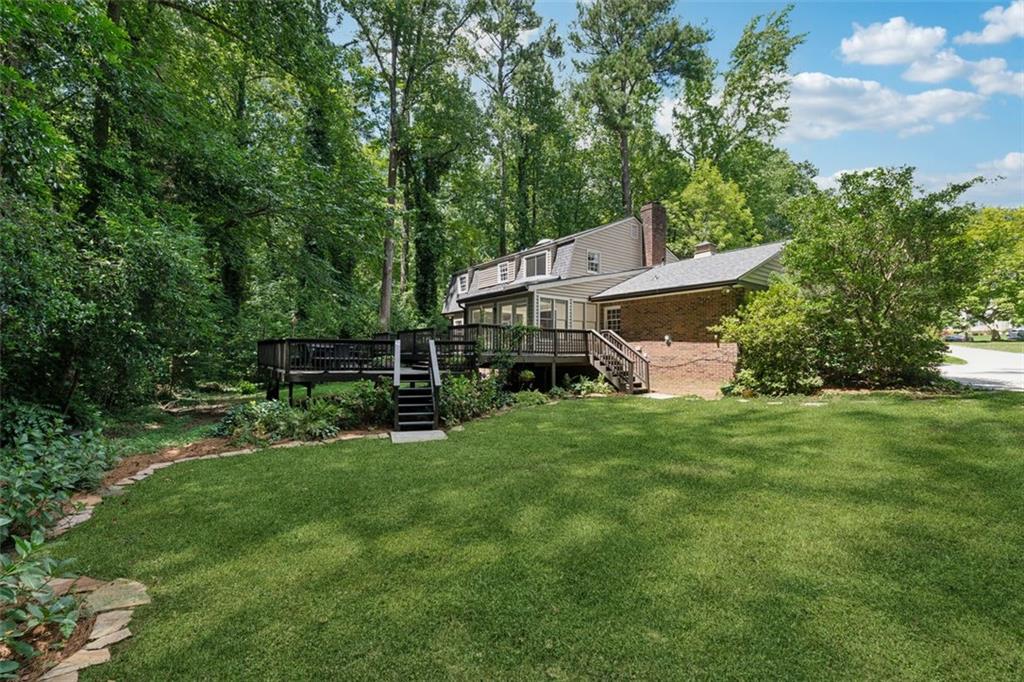 3675 Toxaway Court Chamblee, GA 30341 - Photo 26 of 37 a front view of a house with a garden and trees