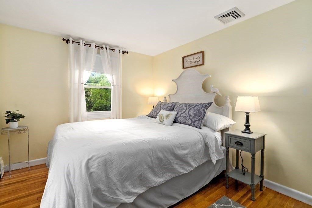 1 Bow Street Wellesley, MA 02481 - Photo 16 of 37 a large bed sitting in a bedroom next to a window and a chandelier