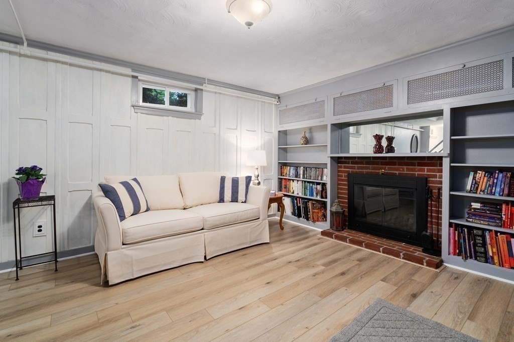 1 Bow Street Wellesley, MA 02481 - Photo 22 of 37 a living room with furniture a fireplace and a book shelf