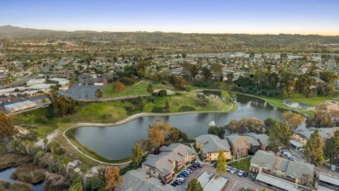 an aerial view of residential houses with outdoor space and lake view