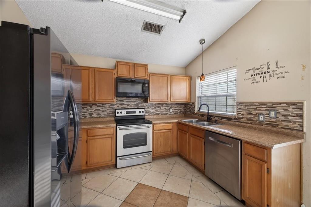920 Danforth Place Arlington, TX 76017 - Photo 9 of 28 a kitchen with stainless steel appliances granite countertop a stove sink and refrigerator