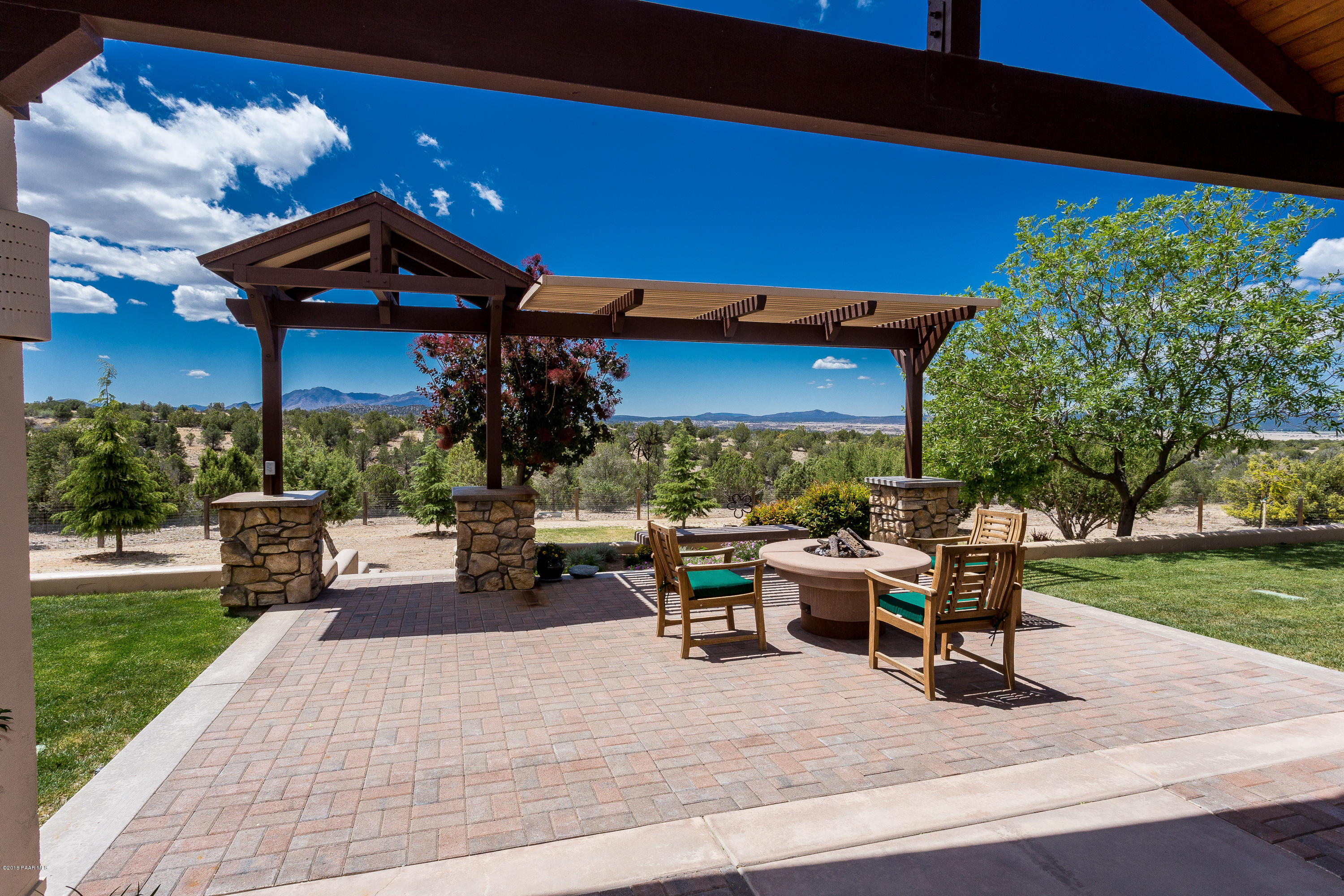 18401 Crossroads Ranch Road Prescott, AZ 86305 - Photo 28 of 51 a view of a patio with a dining table and chairs under an umbrella