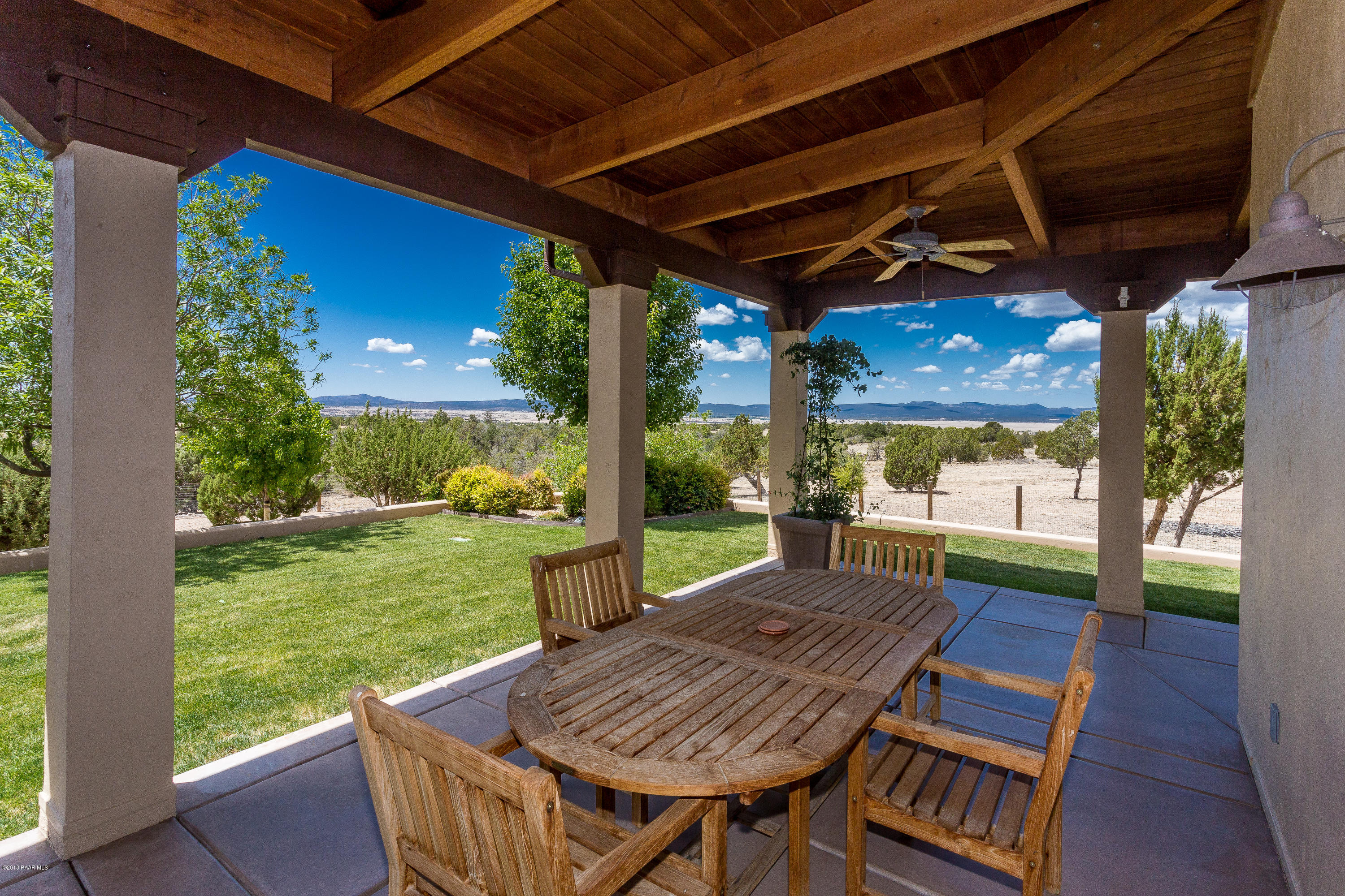 18401 Crossroads Ranch Road Prescott, AZ 86305 - Photo 31 of 51 a view of a patio with a table chairs and a backyard