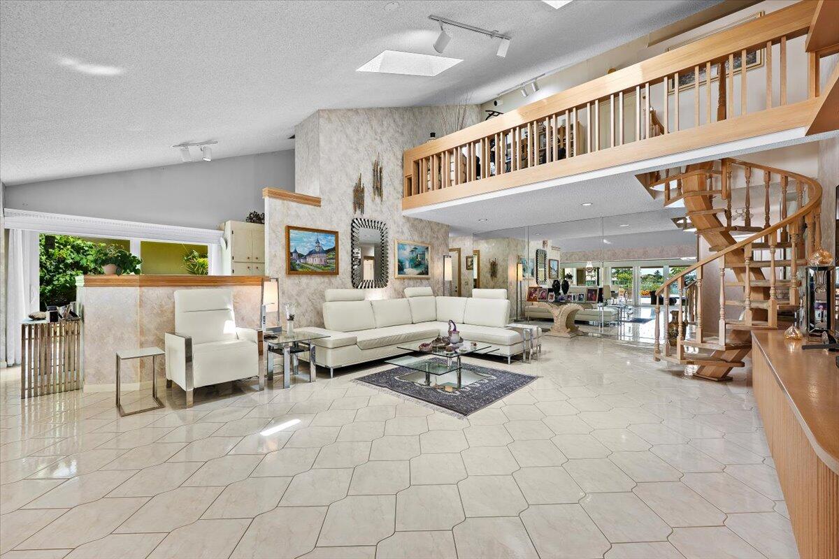 352 River Edge Road Jupiter, FL 33477 - Photo 5 of 56 a living room with furniture a fireplace and a chandelier