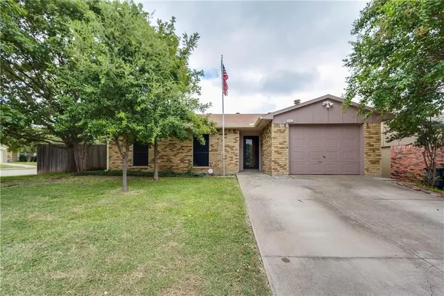 a front view of a house with a yard and a garage
