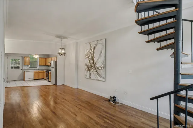 a view of a livingroom with a dinning area wooden floor and staircase