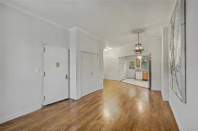 a view of a hallway with wooden floor and chandelier