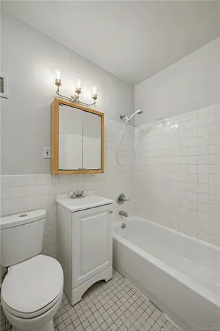 a bathroom with a toilet a sink a mirror and bathtub