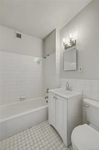 a bathroom with a toilet a sink a mirror and bathtub