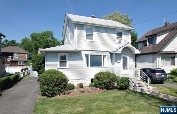 a front view of a house with cars parked