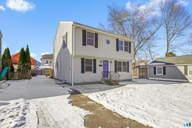 a view of a white house with a large tree