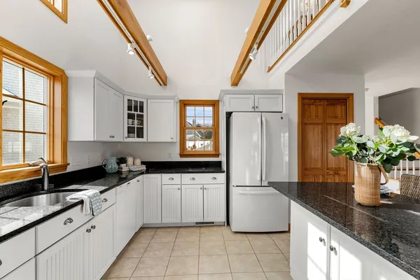 a kitchen with stainless steel appliances granite countertop a sink a stove and a refrigerator