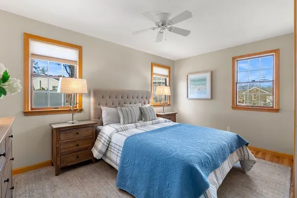 a bedroom with a bed a dresser and next to a window