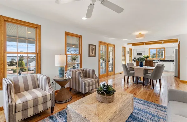 a living room with furniture wooden floor and a floor to ceiling window