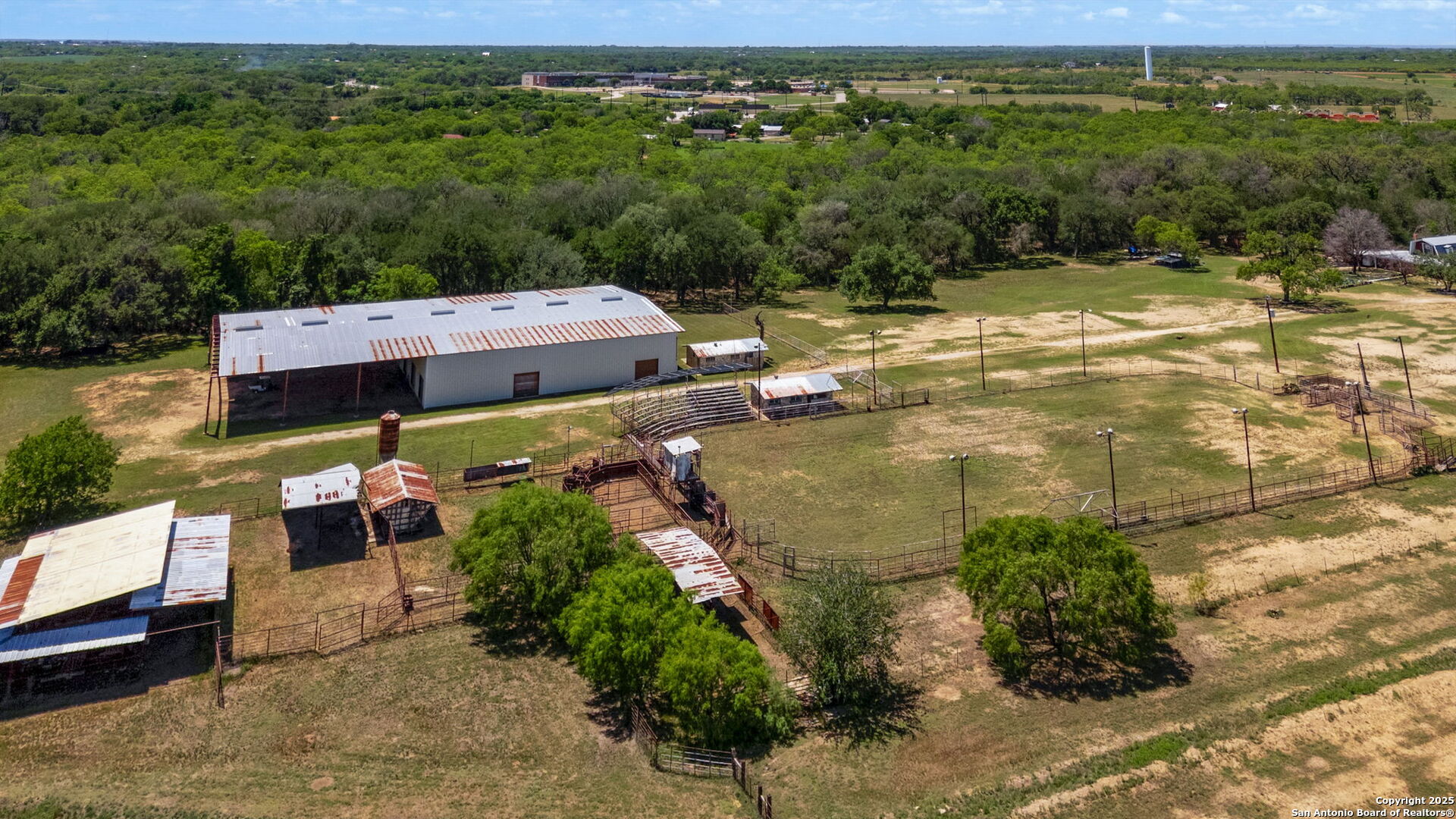 11224 Atkins Road Atascosa, TX 78002 - Photo 16 of 45 a view of a lake with lawn chairs and large trees